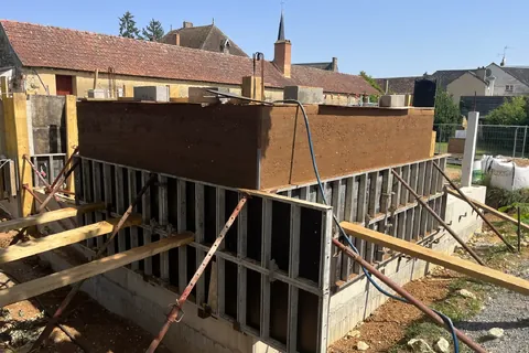 Construction en pisé — Mise en œuvre de terre pisée par banchage.