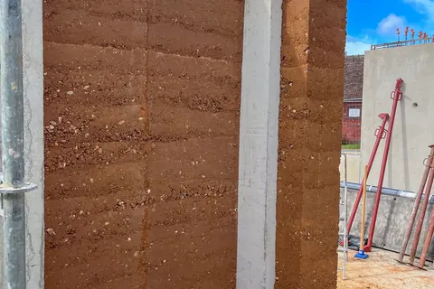 Construction en pisé — Terre pisée avec structure en béton.