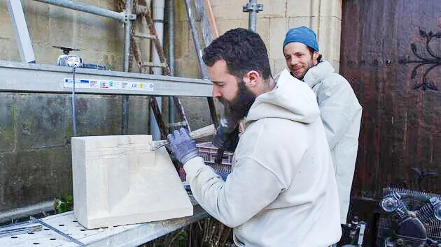 Isaiah réalise une feuillure sur un fenestrage en pierre de Caen à Saint-Vaast-la-Hougue.